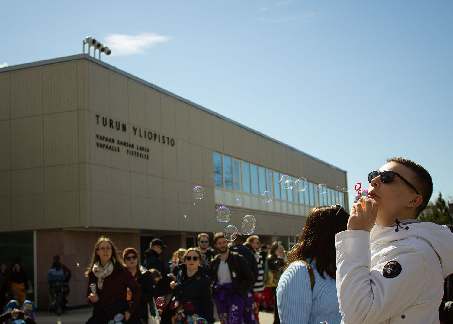 student and bubbles in front of university